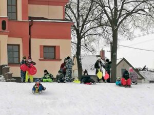 Děti sáňkující na kopečku u sokolovny v Praskačce