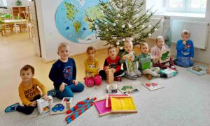 Děti u stromečku s dárky.