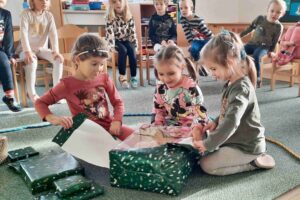 Dívky, které rozbalují vánoční dárky.